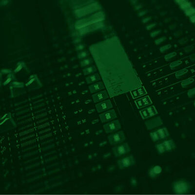 Close-up of a sound mixing console with various knobs, sliders, and buttons, under a green filter.