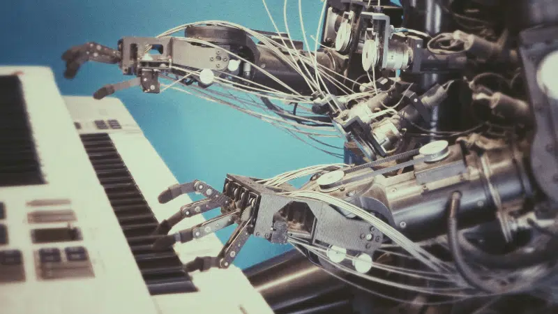 Robotic hands playing a keyboard against a blue background.