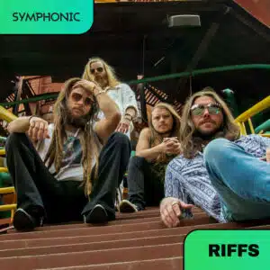 Four men with long hair and sunglasses sit on industrial metal stairs, looking at the camera. Green labels read "SYMPHONIC" and "RIFFS" in the image corners.