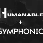 An artist playing an acoustic guitar with the words "HUMANABLE + SYMPHONIC" overlaid in bold white text.