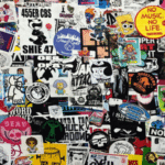 A wall densely covered with assorted colorful stickers, featuring various characters, logos, trademark slogans, and artistic designs overlapping each other.