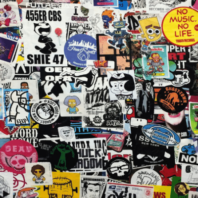 How To Trademark Your Artist Name (Step-By-Step) A wall densely covered with assorted colorful stickers, featuring various characters, logos, trademark slogans, and artistic designs overlapping each other.