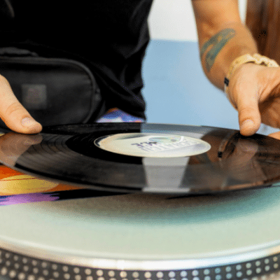 Tips For Independent Artists Looking To Distribute CDs and Vinyl A person places a vinyl record onto a turntable, preparing to enjoy the warm sound of analog music.