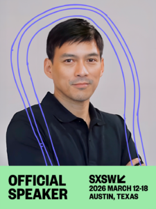 A man in a black shirt stands with arms crossed. Text reads "Official SXSW Speaker, SXSW 2026 March 12-18, Austin, Texas" with blue lines drawn over the image.