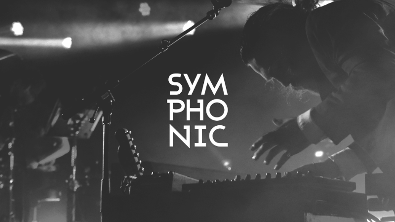 A musician plays a keyboard on stage in dramatic lighting, with the word "SYMPHONIC" and claims of innovation boldly displayed at the center.