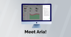 An iMac displays a dashboard with graphs and metrics next to a text document, showcasing AI support. The words "Meet Aria!" appear below the screen.